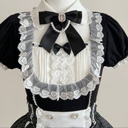 Close-up of the dress neckline with a white collar, black bow, pearl-look accents, and heart-patterned lace.