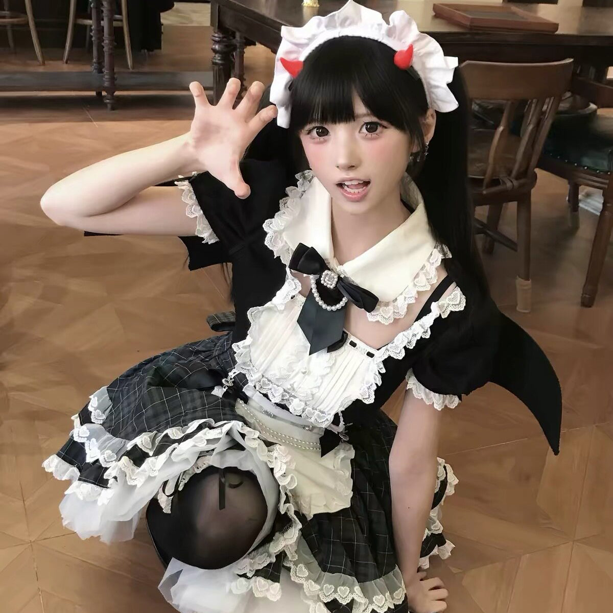 Close styling view of the Lolita dress, showing its white collar, black neck bow, puff sleeves, and lace apron.