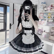 Front mirror view of the black and white Lolita dress, showing its lace bodice, white apron, and flared checked skirt.
